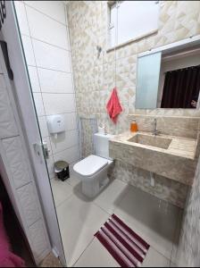 une salle de bains avec toilettes, lavabo et miroir dans l'établissement Aconchego Perfeito em São Pedro SP, à São Pedro
