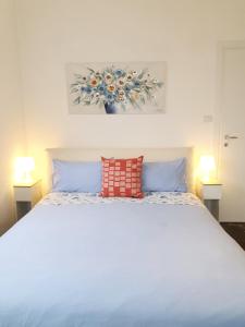 a bedroom with a white bed with two lamps at Fiori e Frutti Guest Home in Almese
