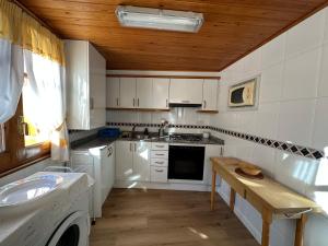 eine Küche mit weißen Geräten und einer Holzdecke in der Unterkunft Apartament Casa Sastre in Espot