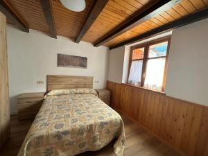 ein Schlafzimmer mit einem Bett und einem großen Fenster in der Unterkunft Apartament Casa Sastre in Espot + 7 Fotos