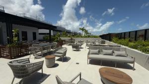a patio with furniture and tables on a building at Hit Cabo Branco Flat Aconchego a 30 metros do mar in João Pessoa