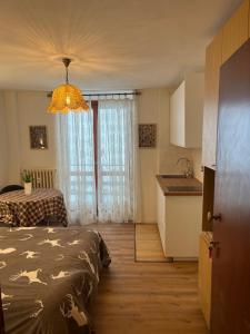 a bedroom with a bed and a kitchen with a window at Appartamento Moon River Monolocale in Limone Piemonte