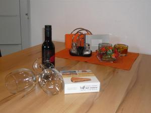 セントにあるChasa Vidos 270 - Familie Scandellaの木製テーブルに置かれたワイン1本とグラス1杯