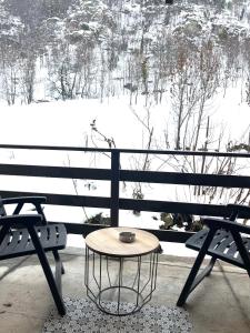 een tafel op een bankje voor een met sneeuw bedekt veld bij Appartamento Moon River Monolocale in Limone Piemonte