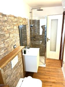 een badkamer met een witte wastafel en een stenen muur bij Appartamento Moon River Monolocale in Limone Piemonte