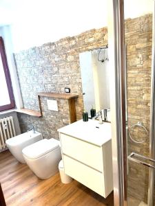 een badkamer met een wastafel, een toilet en een spiegel bij Appartamento Moon River Monolocale in Limone Piemonte