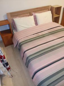 een slaapkamer met een bed met een gestreepte deken bij Sroom in Kardítsa