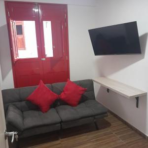 a living room with a couch with two red pillows at La Casa De Mi Tatis in Salento +43 photos