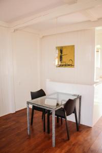 a dining room with a glass table and chairs at Het Dakhuis in Harlingen