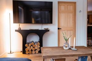 un soggiorno con un camino e una televisione sopra di Barrel sauna & Northern lights getaway a Wasilla