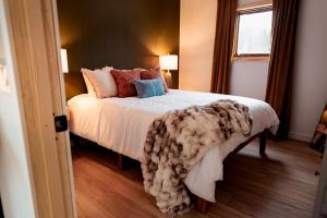 una camera da letto con un letto con una coperta sopra di Barrel sauna & Northern lights getaway a Wasilla