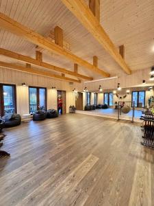 ein großer Raum mit Holzboden und Holzdecken in der Unterkunft Villa Vlada retreat center and 2 houses in Gāršmuiža