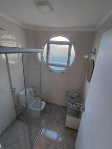 ein Badezimmer mit Dusche und Toilette und einem Fenster in der Unterkunft Studio pé na areia Pereque - Açu in Ubatuba + 7 Fotos