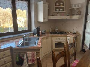 een keuken met een spoelbak en een fornuis bovenste oven bij Fusero1 relax vero borgata fusero 20 giaveno in Coazze