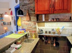 a kitchen with a sink and a brick wall at Condo Studio Paradise Beach in Alexandria
