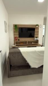een woonkamer met een flatscreen-tv aan de muur bij Apartamento Res Ilha Bella in Passo De Torres