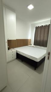 een slaapkamer met een groot bed en een spiegel bij Apartamento Res Ilha Bella in Passo De Torres +8 foto's