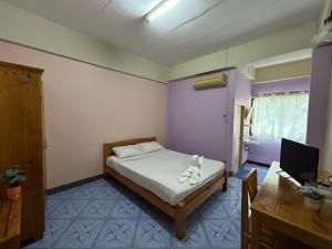 En eller flere senge i et værelse på Apinya Court