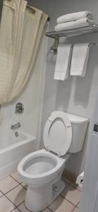 een badkamer met een toilet, een bad en handdoeken bij Stay7 studios Hotel Phoenix Metro in Phoenix