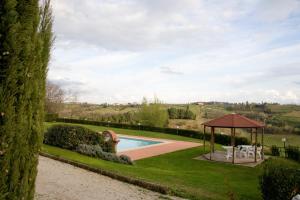 a green lawn with a pool and a tennis court at Agriturismo Marrucola in San Miniato
