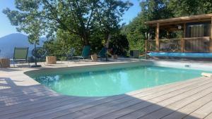 韦纳科CHALET U Castagnu的带椅子和木质甲板的游泳池