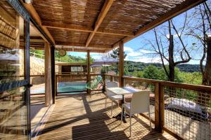 韦纳科CHALET U Castagnu的露台上有一张桌子和几把椅子