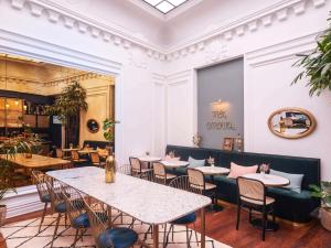 un restaurant avec des tables et des chaises et un plafond dans l'établissement Mercure Nantes Centre Passage Pommeraye, à Nantes