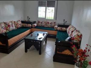 a living room with a couch and a coffee table at bel appartement à Martil in Martil +1 photo