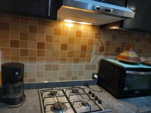 a kitchen with a stove and a microwave at bel appartement à Martil in Martil