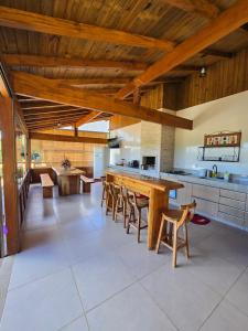 una cucina con un lungo tavolo in legno e sedie di Casa temporada Grecco Vidal a Venda Nova do Imigrante