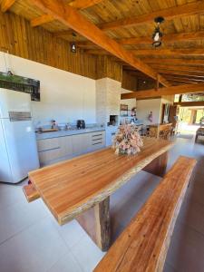 una cucina con un tavolo di legno e un frigorifero di Casa temporada Grecco Vidal a Venda Nova do Imigrante
