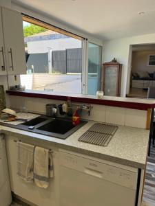 een aanrecht met een wastafel en een raam bij Villa Josèphe in Capbreton