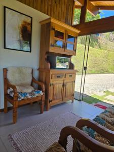 soggiorno con armadio in legno e sedia di Casa temporada Grecco Vidal a Venda Nova do Imigrante