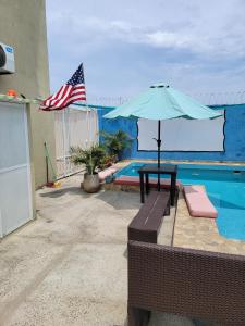a table with an umbrella next to a pool at Cabana Acunas House in Santa Marta