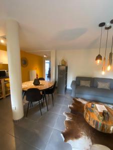 een woonkamer met een tafel en een bank bij Appartement rez Terrasse et Jardin in Huy