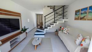 a living room with a couch and a staircase at Mansão dos Mares 06 in Ilhéus