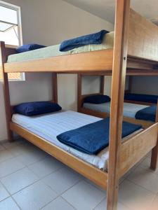 2 stapelbedden in een kamer met blauwe lakens bij Hostel Farol in Pontal do Paraná +13 foto's