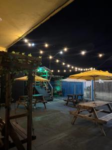 een patio met tafels en parasols in de nacht bij Hostel Farol in Pontal do Paraná