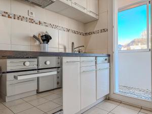 une cuisine avec des appareils blancs et une grande fenêtre dans l'établissement Le 19 Lavigne - Parking, à Saint-Martin-dʼHères