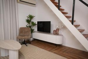 a living room with a tv and a chair at One Apartments TLV in Tel Aviv
