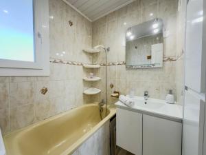 a bathroom with a sink and a tub and a mirror at Le 19 Lavigne - Parking in Saint-Martin-dʼHères +41 photos