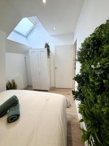 una camera da letto con un letto e una grande pianta di La Jungle - T2 à Melesse a Melesse