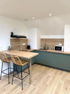 una cucina con un tavolo di legno e due sedie di La Jungle - T2 à Melesse a Melesse