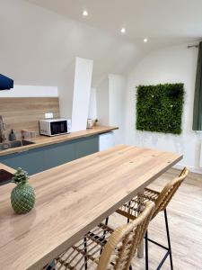 una cucina con tavolo e sedie in legno di La Jungle - T2 à Melesse a Melesse Altre 8 foto