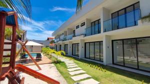 an exterior view of a building with a yard at Mansão dos Mares 06 in Ilhéus