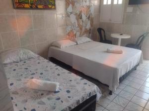 een kamer met 2 bedden en een tafel bij Pousada Mamulengo in Porto De Galinhas