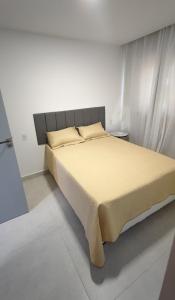 a bed in a white room with a large bed at Mansão dos Mares 06 in Ilhéus +17 photos