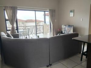 ein Wohnzimmer mit Couch und Balkon in der Unterkunft 54 Topanga Holiday Accommodation in Margate + 13 Fotos