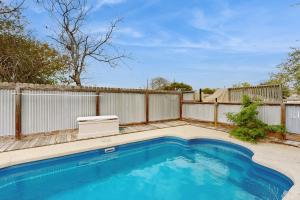 a swimming pool in a backyard with a fence at The Saltbox in Padre Island