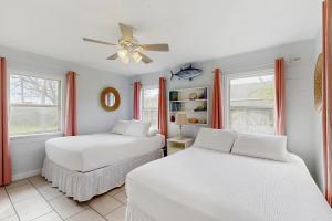 two beds in a room with two windows at The Saltbox in Padre Island +16 photos